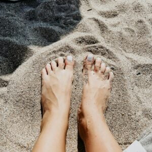woman feet on beach sand