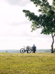 man sitting with bike on bench